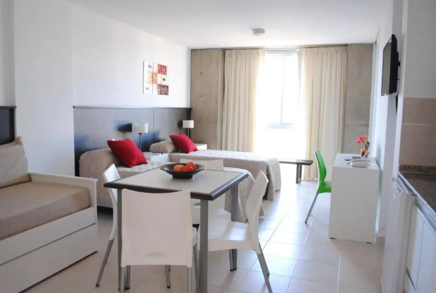 Habitación Cuádruple Premium de Torre Potosí con camas, diván, mesa con sillas y cocina