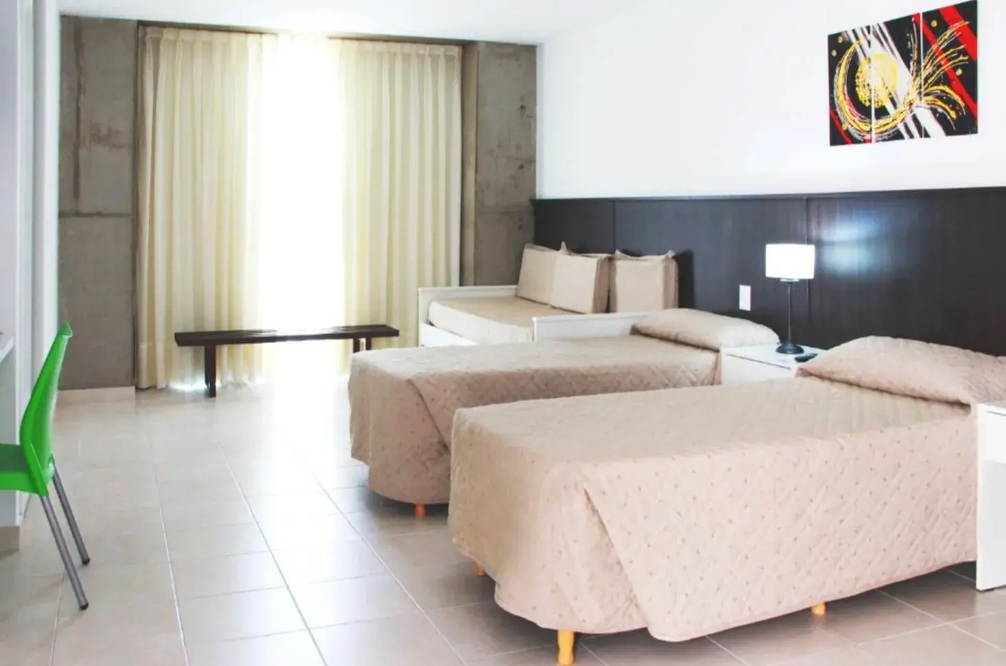 Habitación Triple Superior de Torre Potosí con camas y ventanal con cortinas
