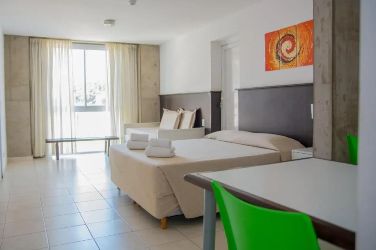 Dormitorio de Torre Potosí con cama, ventanal y mesa