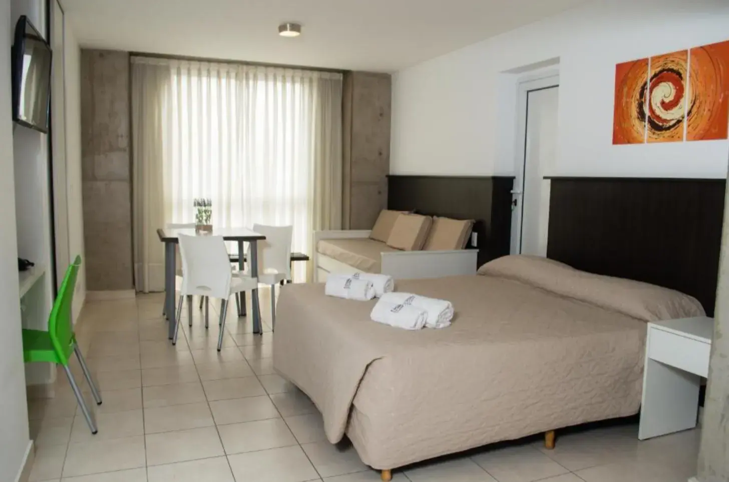Departamento de Torre Potosí con cama, mesa con sillas y cortinas