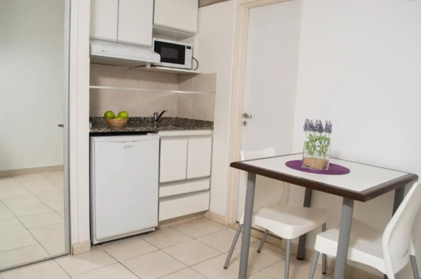 Kitchenette con heladera y mesa con sillas en un departamento de Torre Potosí
