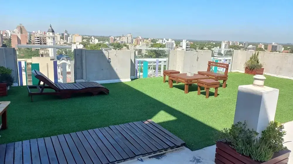 Terraza de Torre Potosí con césped sintético, reposeras y vista a la ciudad